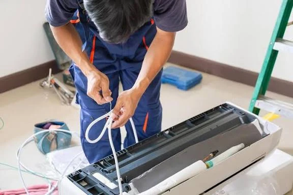 Technician preparing wiring for an indoor air conditioning unit