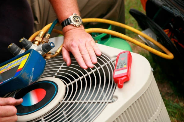 Technician checking an outdoor air conditioner with a temperature meter and service equipment